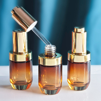 Flacon compte-gouttes à pression en verre rond transparent ambré de 35ml à prix compétitif pour sérum flacon d'huile capillaire avec bouton plaqué or