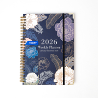 Agenda hebdomadaire 2026 personnalisé avec logo, couverture florale, spirale dorée, couverture rigide avec fermeture élastique et protège-coins