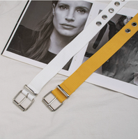 Cette ceinture en toile tissée entièrement blanche, au style audacieux, avec boucle à plaque et œillets métalliques argentés sur toute la longueur, offre une ambiance cool et punk pour le streetwear.