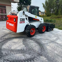 Bobcat S300 d'occasion à levage vertical, moteur Kubota, attache rapide BobTach pour la construction et le déneigement avec balayeuse, prix bas