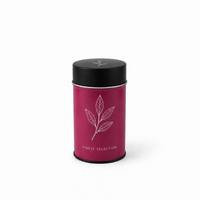 Boîte à thé ronde en métal rose personnalisée avec couvercle noir uni et motif floral blanc pour l'emballage de thé en vrac de qualité supérieure