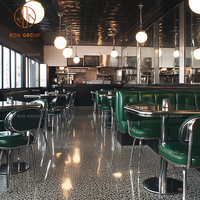 Ensemble de meubles de restaurant, café et bar moderne, tables à manger avec base en métal, sièges en cuir vert et canapé en cuir incurvé