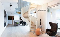 Escalier en métal courbé moderne de haute qualité avec rampe en verre pour usage intérieur dans un appartement ou une bibliothèque