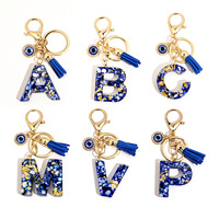 Porte-clés en résine Lettre Œil Turc avec breloque alphabet incrustée de feuille d'or, pompon et accessoires dorés, accessoire de mode pour sac