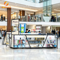 Comptoir de présentation en verre avec cadre en métal noir pour la réparation de téléphones et la vente d'accessoires en centre commercial