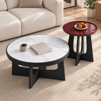 Ensemble de tables basses rondes avec plateau blanc marbré et table d'appoint rouge brillante pour un salon moderne et une véranda.
