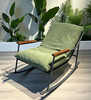 Fauteuil inclinable moderne en tissu suédé gris, avec structure en métal courbé noir, pour salon, hôtel ou salle de séjour.