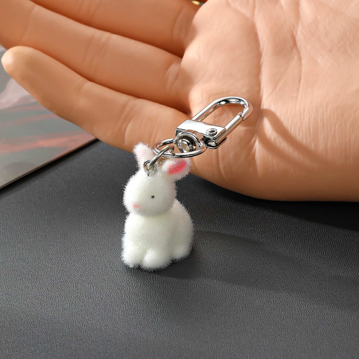 Assis droit, on voit un petit lapin blanc aux petits yeux.