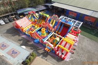 Parc d'attractions gonflable sur le thème du carnaval avec toboggans et jeux interactifs, aire de jeux commerciale pour événements en plein air