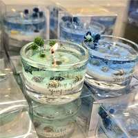 Bougie parfumée en verre sur le thème de l'océan, avec coquillages naturels, sable fin, fleurs bleues séchées et paysage tridimensionnel décoratif en cire parfumée