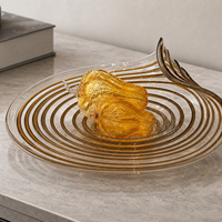 Luxueuze gedraaide spiraalvormige glazen schaal met amberkleurige tint voor fruitpresentatie in de woonkamer, op de salontafel of dressoir.