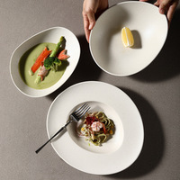 Assiettes à dîner en céramique mate mouchetée de forme ovale irrégulière, bols à soupe en céramique pour une salle à manger moderne et minimaliste