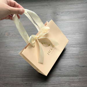 Sacs cadeaux de luxe couleur pêche avec estampage à chaud doré - Sacs shopping en satin avec nœud pour produits de soin et cosmétiques - Product Image 1