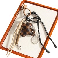 Petit porte-clés et pendentif pour sac ou téléphone, en alliage et matériaux mixtes, avec breloque ours en peluche en cuir et cordon tressé semi-artisanal, en forme de raquette de tennis