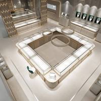 Solution complète de design d'intérieur pour bijouterie de luxe beige et or, avec comptoir d'exposition incurvé en verre sur mesure pour îlot de bijoux