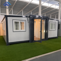 Maison modulaire en conteneur blanche fabriquée en usine avec cadre noir, porte double en verre, plusieurs fenêtres, maison préfabriquée portable