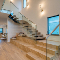 Escalier à poutre centrale ouverte avec rampes et marches en verre flottants pour villa moderne à usage intérieur