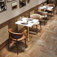 Table à manger carrée moderne de luxe en marbre blanc mat avec base noire dorée pour restaurant, hôtel, café, appartement