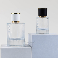 Flacon de parfum élégant en verre transparent côtelé rond de 30 ml, 50 ml, 100 ml, avec design sérigraphié, bouchons noirs et blancs, et capuchon pulvérisateur doré.