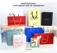 Bolsas de regalo de cuerda de papel blanco personalizadas para peluca Bolsas de compras de ropa perforadas por gravedad ecológicas de lujo con relieve