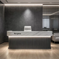 Bureau d'accueil moderne en bois à lattes avec comptoir anthracite et lettres dorées lumineuses à LED pour hall d'hôtel ou bureau
