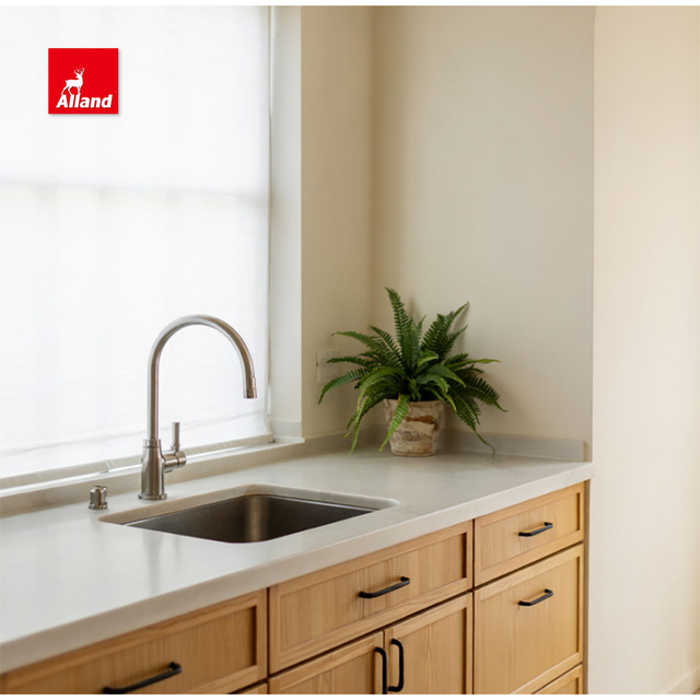 White oak kitchen cabinetry with stone countertop and undermount sink