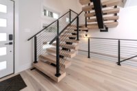 Escalier intérieur moderne à monopoutre avec garde-corps en câble et marches en bois massif