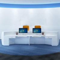 Bureau d'accueil moderne avec panneau frontal incurvé blanc, deux postes de travail et éclairage d'accentuation bleu