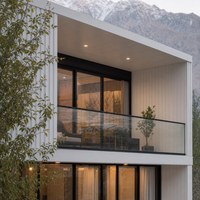 Maison en conteneurs d'acier à deux étages avec terrasse sur le toit, grandes baies vitrées et escalier extérieur