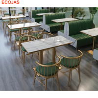 Ensemble de banquettes de restaurant de luxe avec revêtement vert, chaises dorées et tables aspect pierre