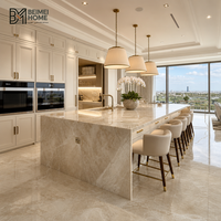 Meubles de cuisine modernes blanc crème, îlot cascade en quartzite Taj Mahal à bords biseautés, menuiserie de penthouse