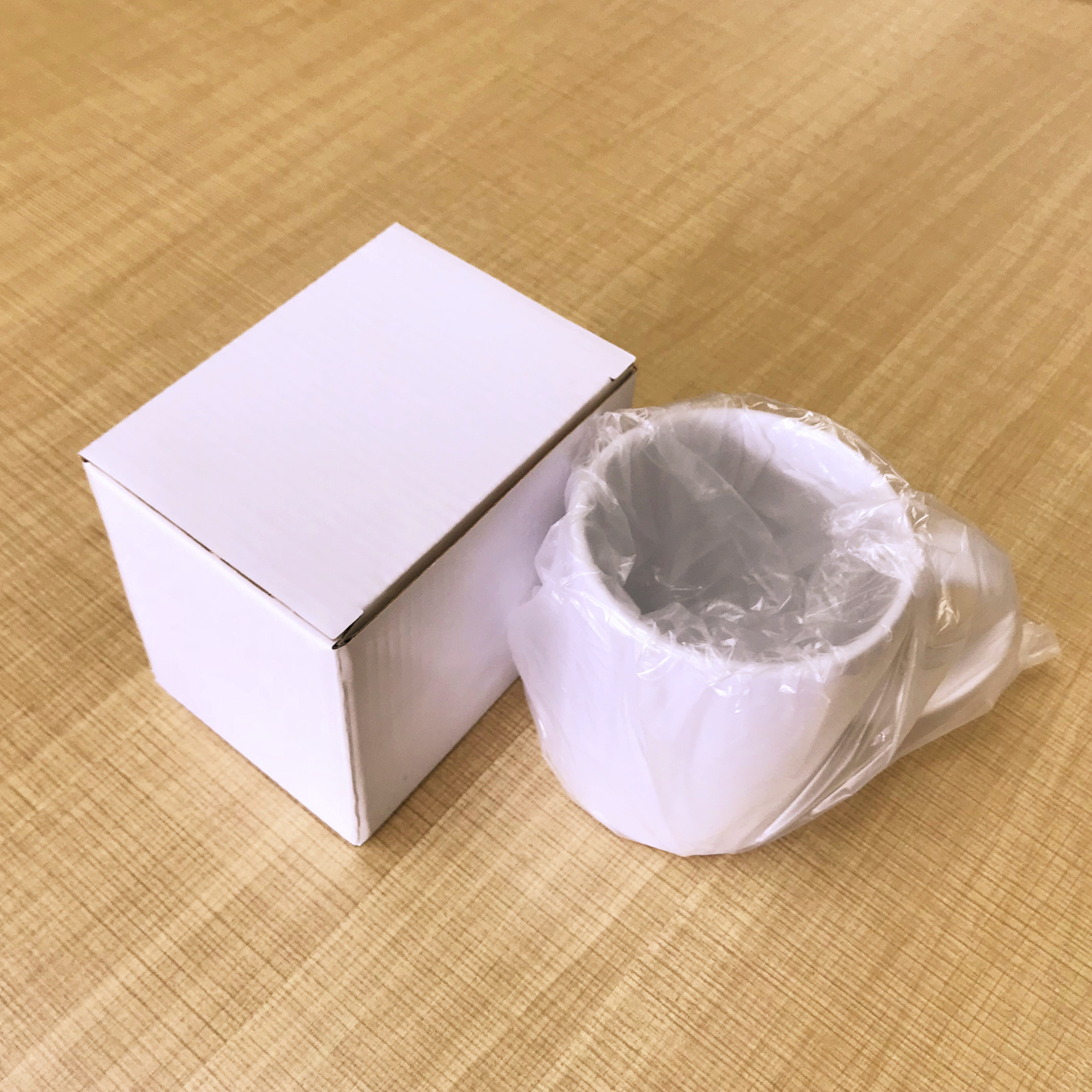 Taza para transferencia de calor en blanco, en caja blanca pequeña.
