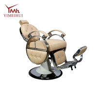 Fauteuil de barbier inclinable robuste de style rétro, en cuir capitonné beige, avec structure en métal poli, rotation à 360°