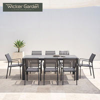 Table de repas d'extérieur avec plateau en pierre frittée, structure en aluminium thermolaqué, mobilier de patio avec chaises en maille pour projets hôteliers et de complexes de villégiature