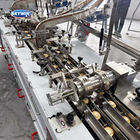 La machine de sandwich à biscuits à la crème Skywin 3 + 2 à deux voies se connecte à la machine à emballer les poils