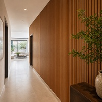 Panneau mural linéaire WYRAX en bois de teck WPC pour hall d'entrée et couloir, avec accent vertical pleine hauteur et aménagement à rainures verticales continues