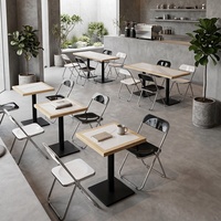 Ensemble de salle à manger industriel, tables en bois massif texturé et chaises pliantes en acrylique transparent pour cafés