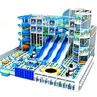 Aire de jeux intérieure sur le thème de la neige d'hiver, château gonflable avec grand toboggan et piscine à balles blanches
