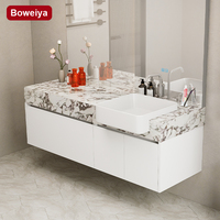 Meuble-lavabo mural moderne en dalles de roche résistantes à l'eau avec vasque en céramique, égouttoir en cuivre et miroir intelligent pour hôtel