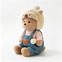 Peluche Ours Marron Adorable avec Chapeau de Trappeur et Salopette en Jean – Jouet en Peluche Doux et Tendance