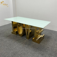 Table de salle à manger NIKA de luxe avec lettres dorées brillantes LOVE, structure en acier inoxydable et plateau en verre, idéale pour les mariages, les événements et les fêtes