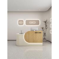 Comptoir de réception simple en MDF rectangulaire arrondi pour magasin de vêtements, salon de beauté, studio de yoga, design style crème, finition cuite