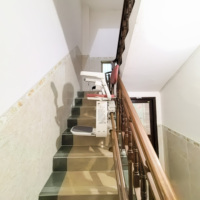 Ascenseur à siège incurvé assurant la sécurité et la commodité pour les personnes âgées vivant à domicile