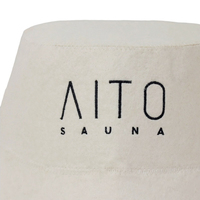 Un gorro de sauna de lana pura color crema que convierte la lambda griega en un distintivo de marca y convierte cada sala de vapor en una declaración de diseño.