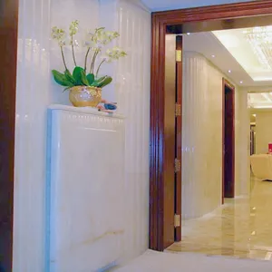 Huashow แผ่นพื้นหินโอนิกซ์สีขาวแผ่นพื้นหลังหินอ่อนโอนิกซ์ธรรมชาติการออกแบบผนังหินอ่อนที่ทันสมัยโอนิกซ์โรงแรม