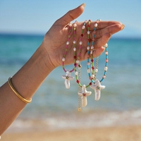 Collier chaîne micro-perles couleur bonbon avec pendentif croix en coquillage naturel incrusté de petites pierres CZ étincelantes – Collier d'été pour la plage