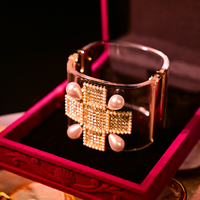 Bracelet jonc audacieux pour femme, imitation perles et cloutages dorés, style punk, bijou statement avec design manchette et bracelet de montre