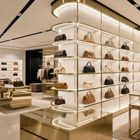 Vitrine de présentation de sacs à main en acier inoxydable doré de luxe sur mesure avec éclairage LED incurvé pour boutique de détail