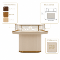 Vitrine à bijoux ovale moderne en verre avec base rainurée et surface incurvée éclairée par LED