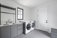 Meubles de cuisine modernes bicolores sur mesure, anthracite et chêne clair, sans poignées, avec îlot large et étagères LED, pour projet résidentiel